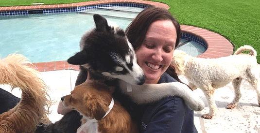 daycare attendant hugging dogs